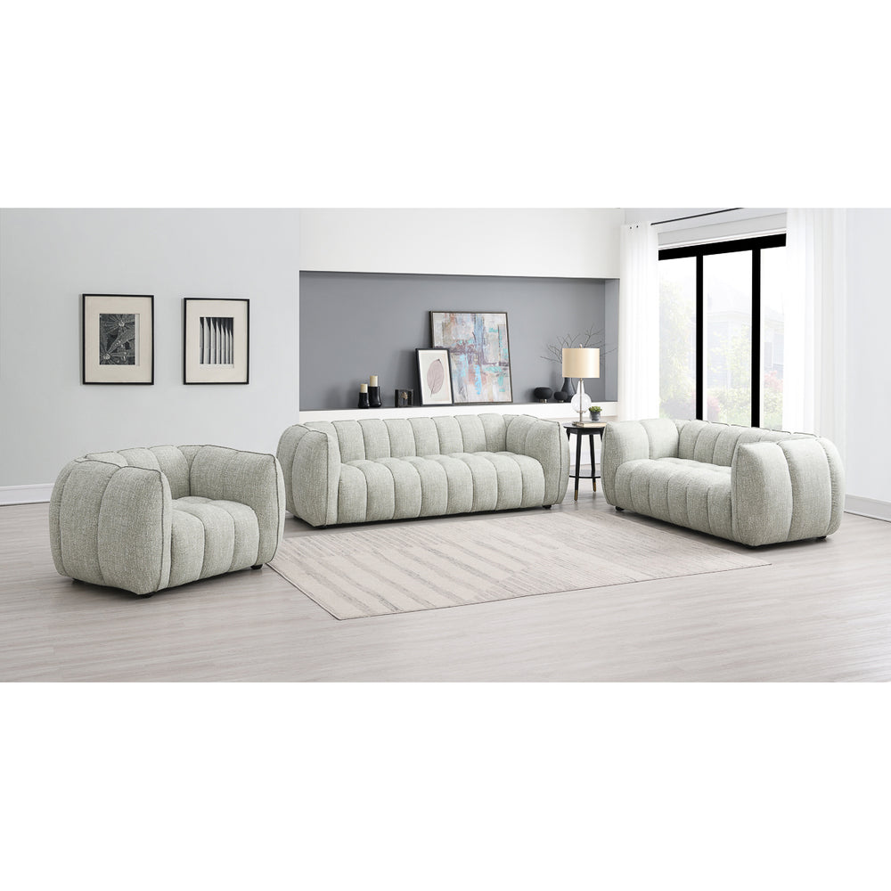 A modern living room featuring the Avriio Vienna Fluted Arm Chair in pale green fabric, a large beige rug, minimalist decor, wall art, shelves, a lamp, and bright windows with sheer white curtains—White Glove Home Delivery available.