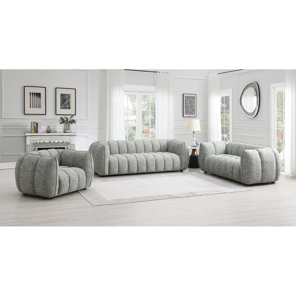A modern living room features the Avriio Vienna Fluted Arm Chair in Winter Moss Fabric, paired with a gray tufted sofa and loveseat on a large rug. Enjoy White Glove Home Delivery—furniture placed and set up in your room of choice.